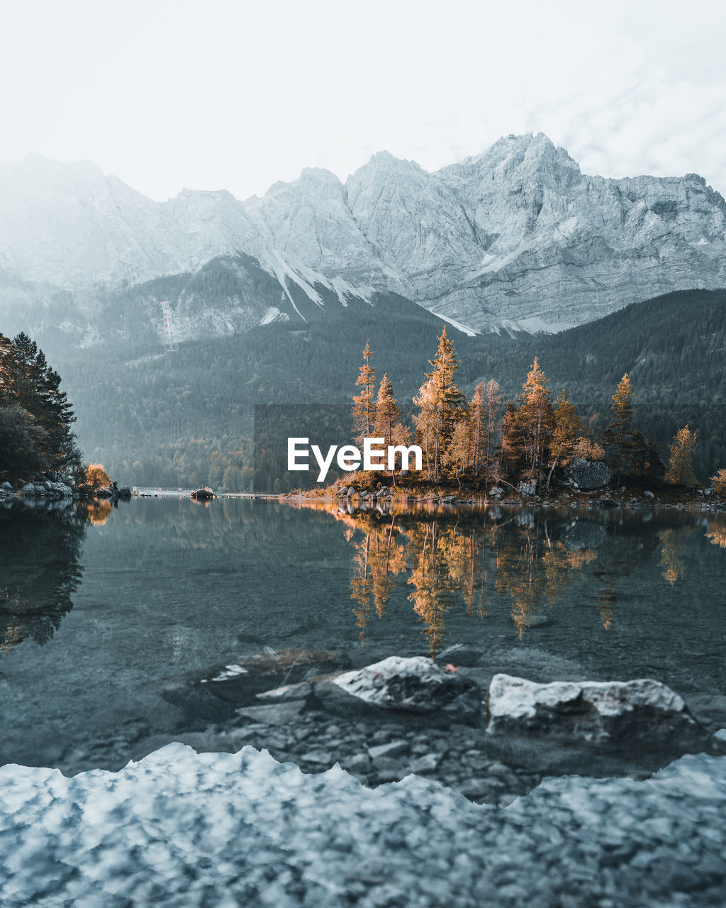 Scenic view of lake by snowcapped mountains against sky