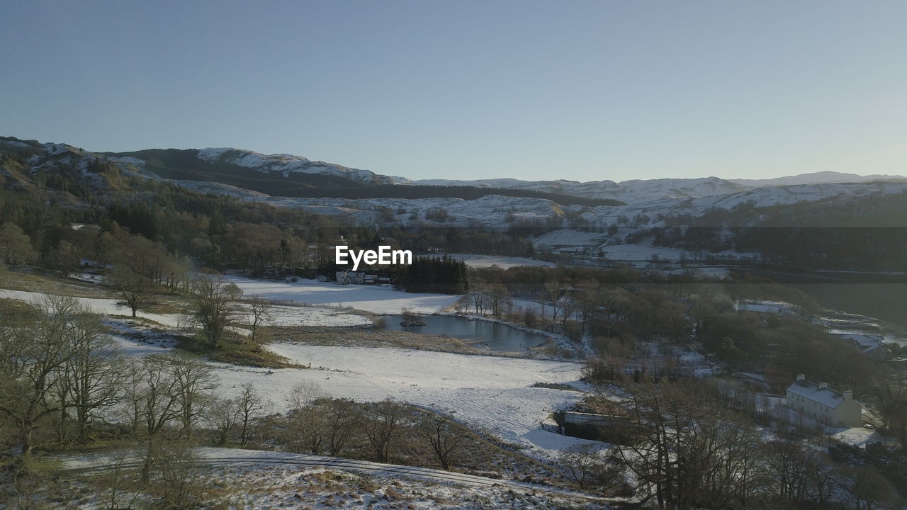 SCENIC VIEW OF FROZEN LAKE AGAINST CLEAR SKY DURING WINTER