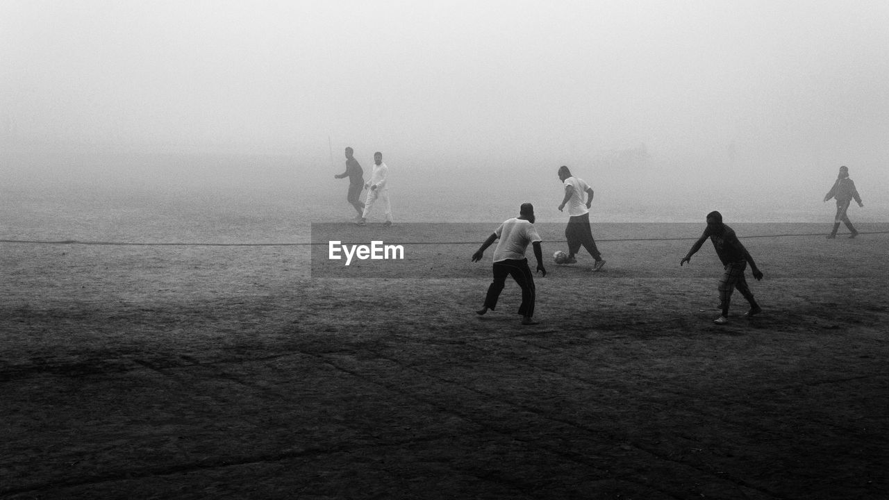 High angle view of people playing soccer in fog