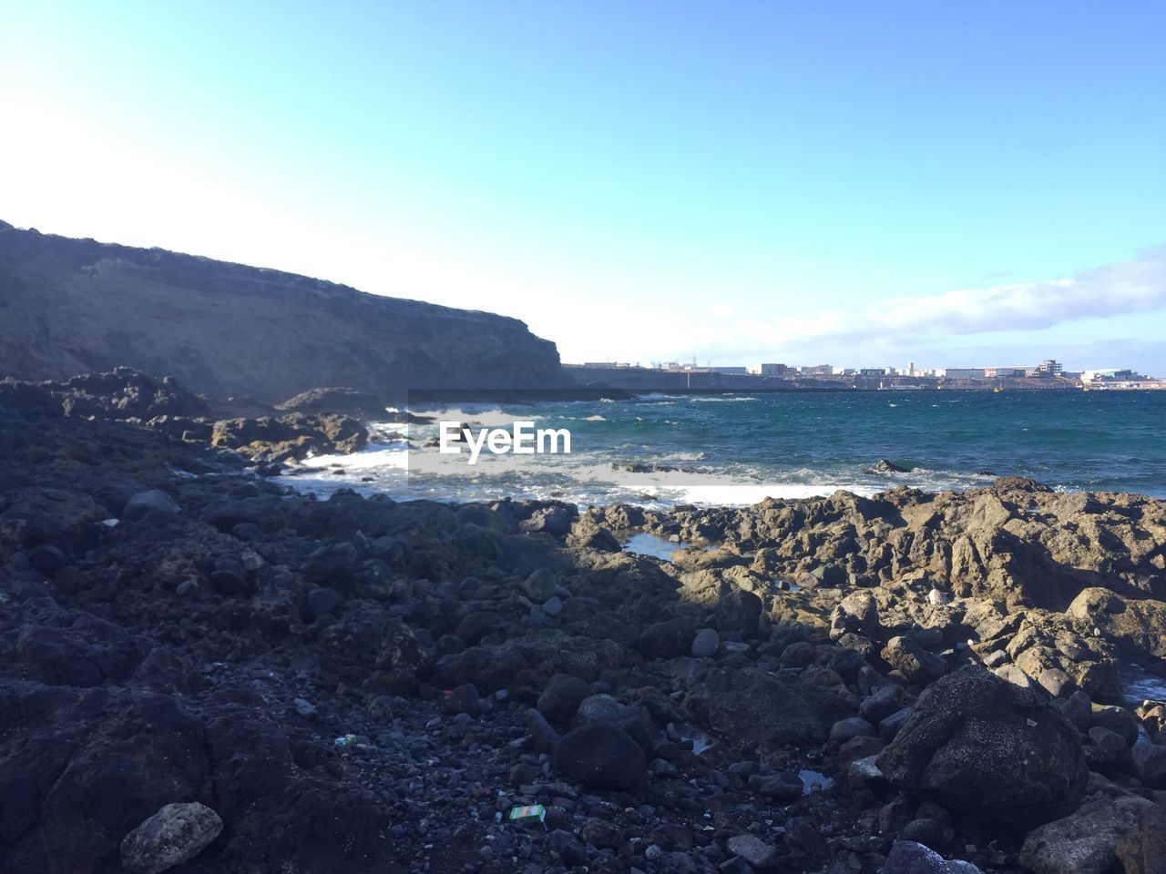 SCENIC VIEW OF SEA AND MOUNTAINS AGAINST CLEAR SKY