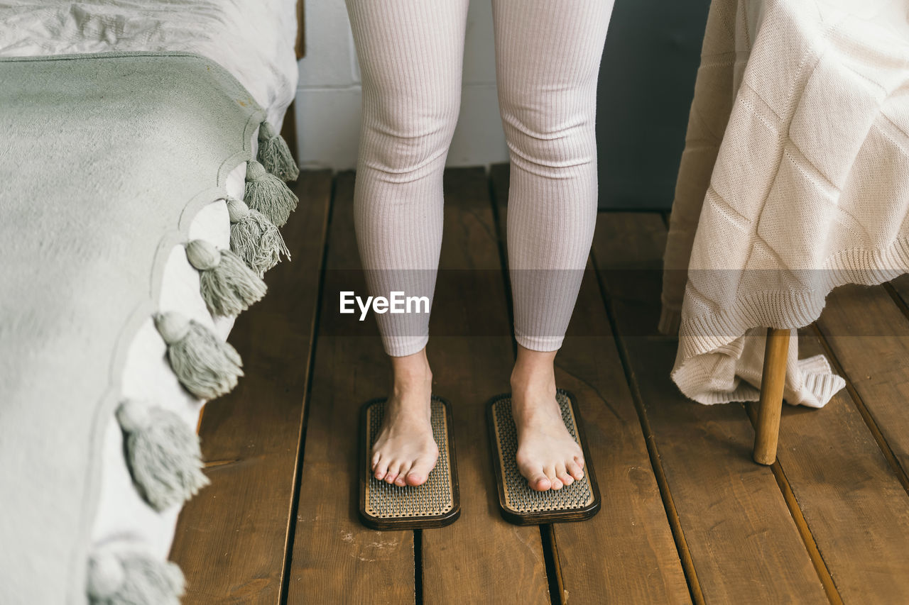 Low section of woman standing on hardwood floor