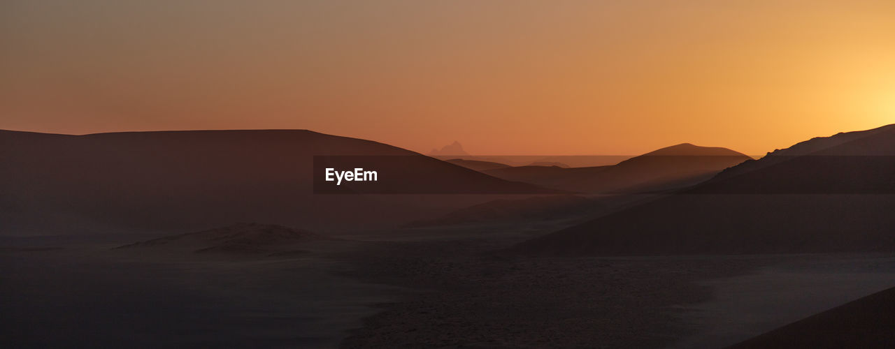 Scenic view of silhouette mountains against sky during sunset