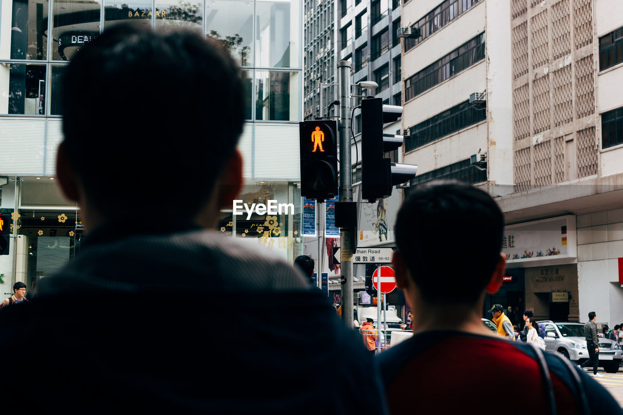 Rear view of people against buildings