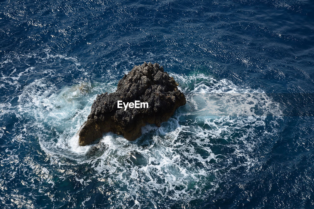 HIGH ANGLE VIEW OF WAVES ON SEA