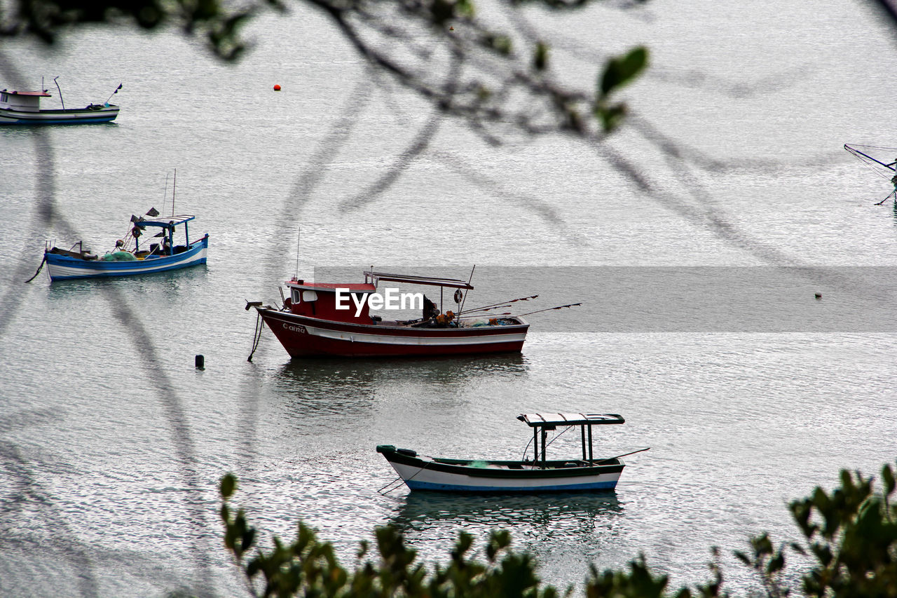 HIGH ANGLE VIEW OF SAILBOATS MOORED ON RIVER