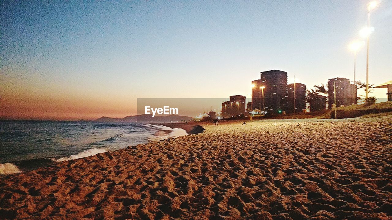 View of calm beach against clear sky