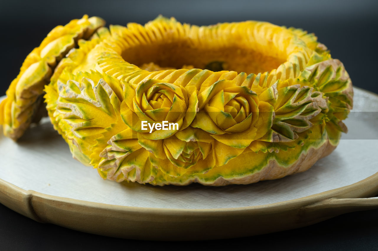 CLOSE-UP OF YELLOW ROSE IN PLATE