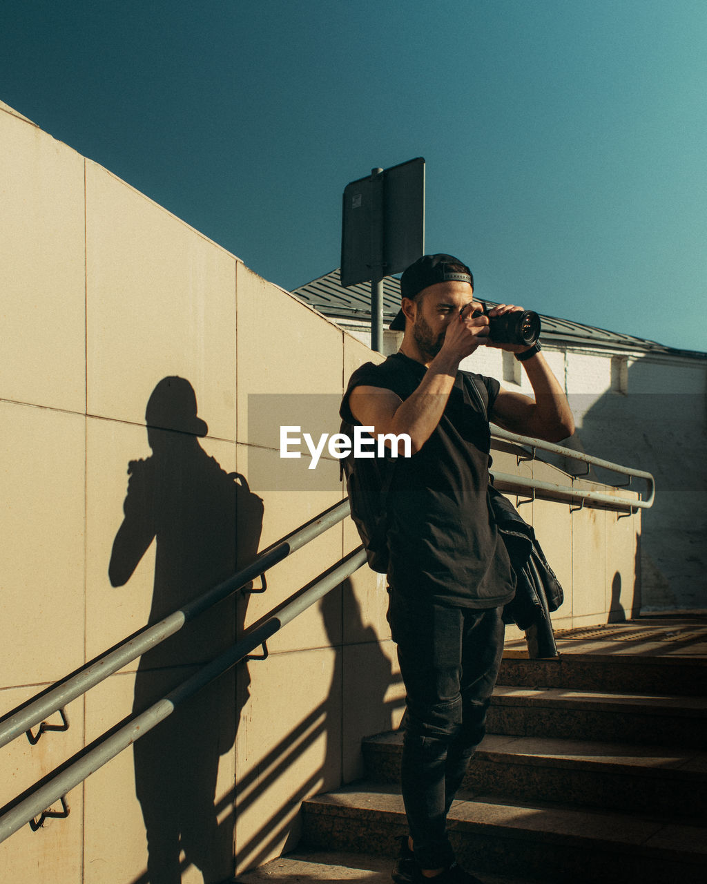 Full length of man standing on railing against sky