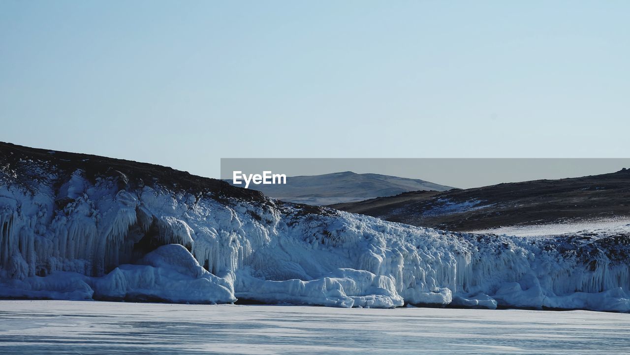 Scenic view of snowcapped mountains against clear sky