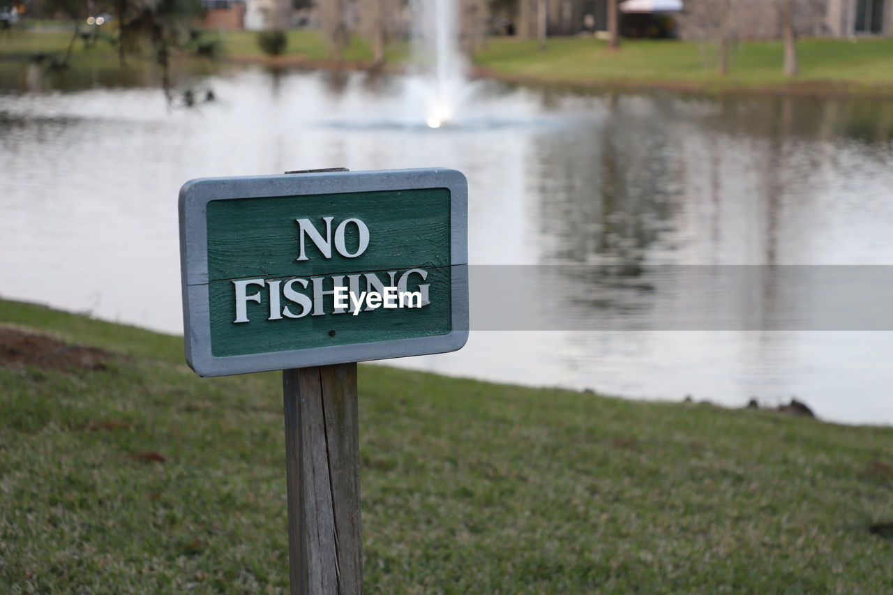 Warning sign at edge of lake