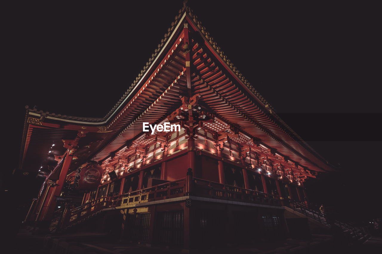 LOW ANGLE VIEW OF ILLUMINATED BUILDINGS AT NIGHT