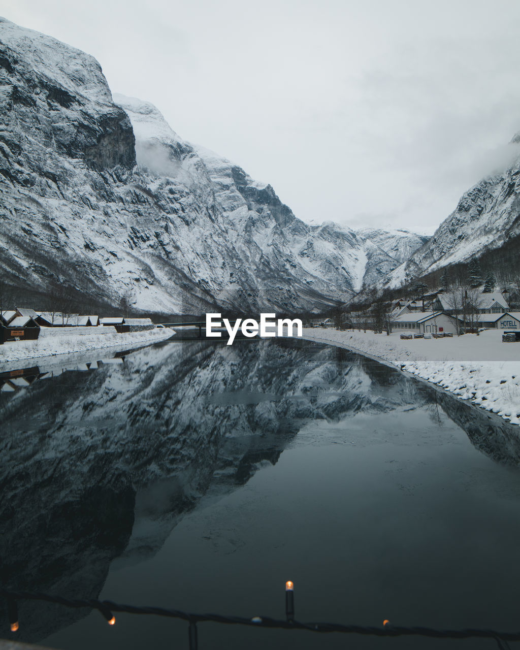 Scenic view of lake by snowcapped mountains against sky