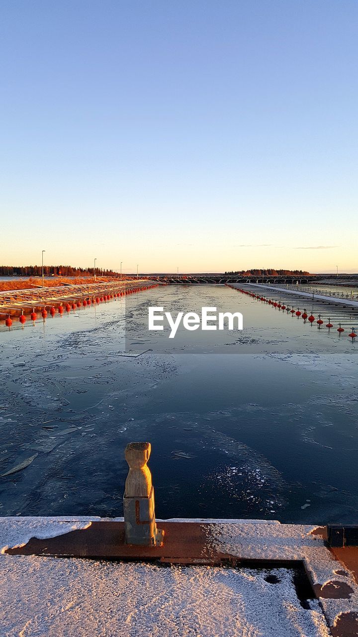 Scenic view of lake against clear sky during sunset