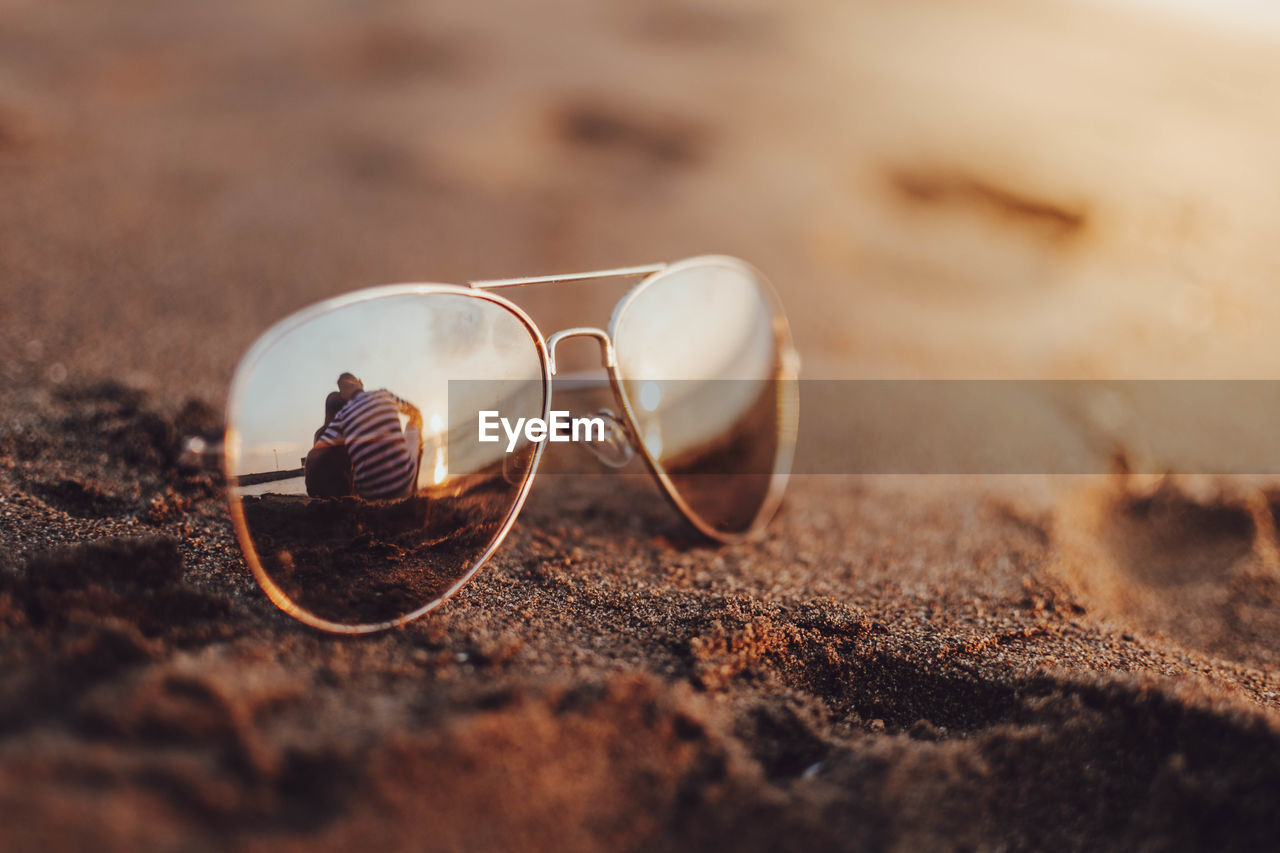 Close-up of sunglasses on sand