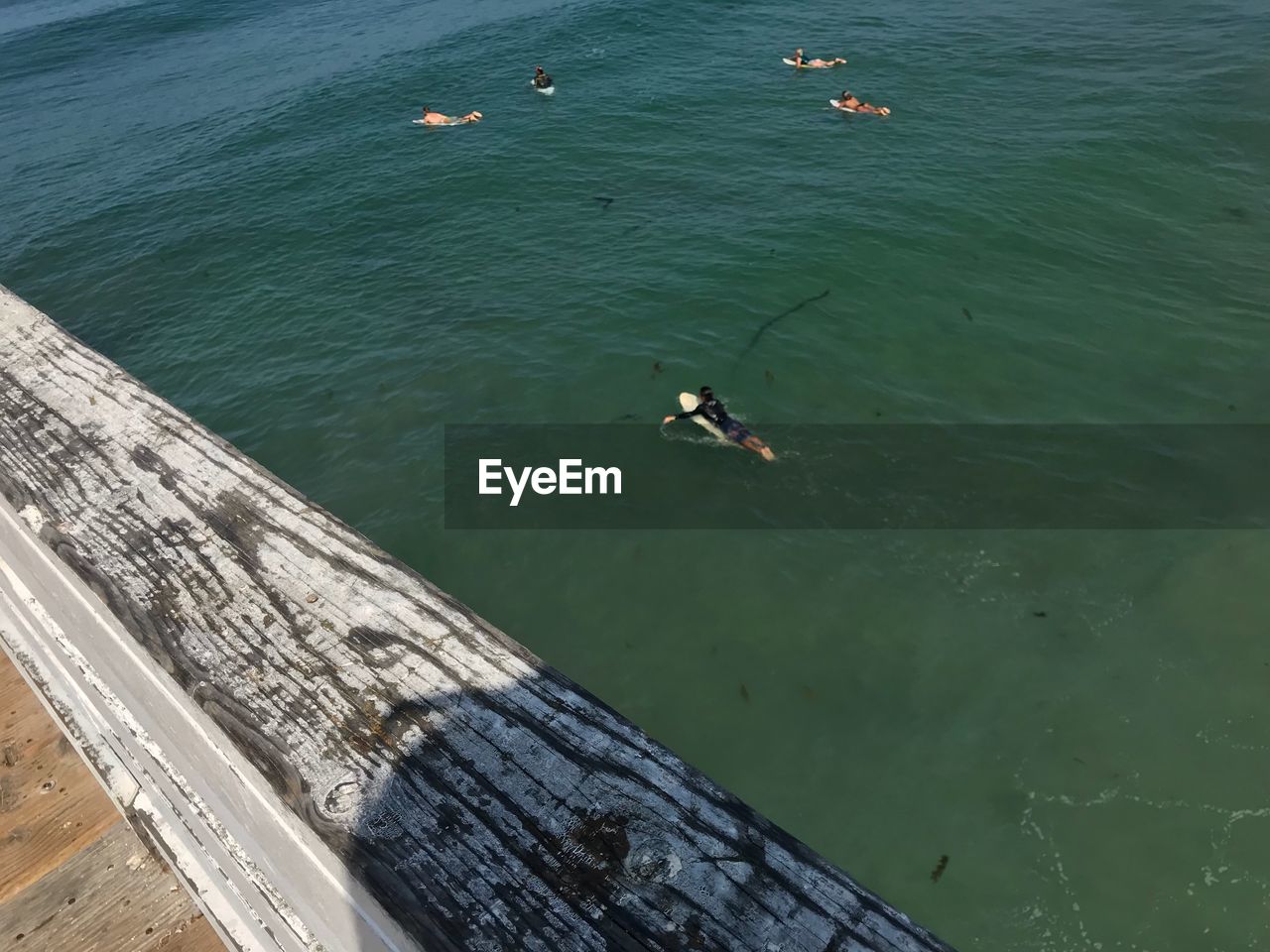 HIGH ANGLE VIEW OF PEOPLE SWIMMING ON SEA