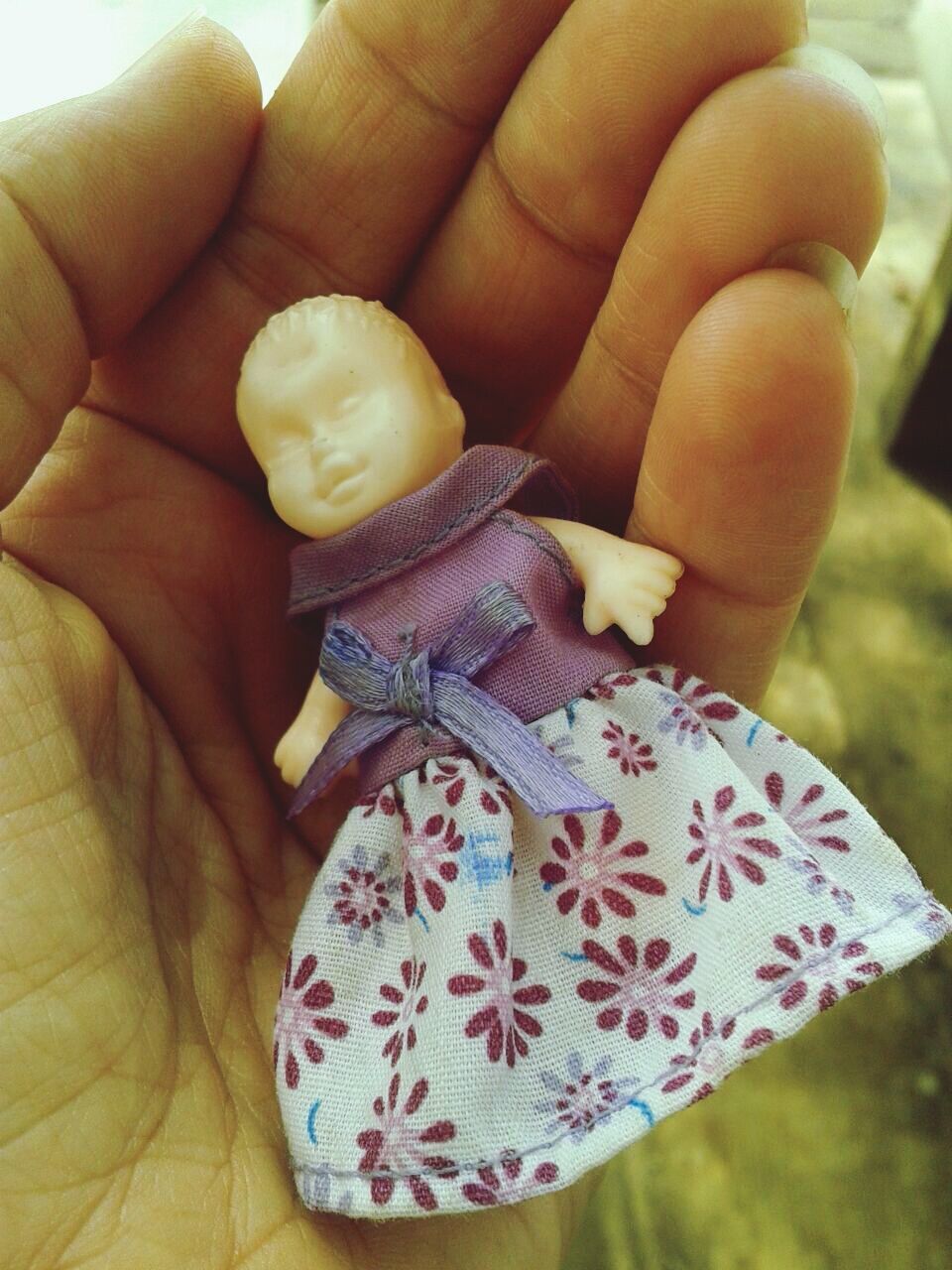 Cropped hand holding toy doll