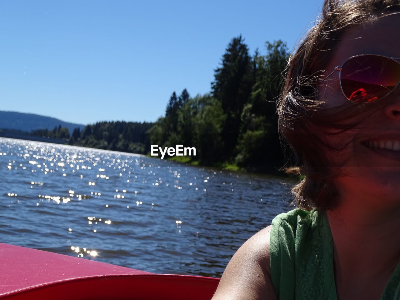 Close-up of happy woman on boat in river against sky during sunny day