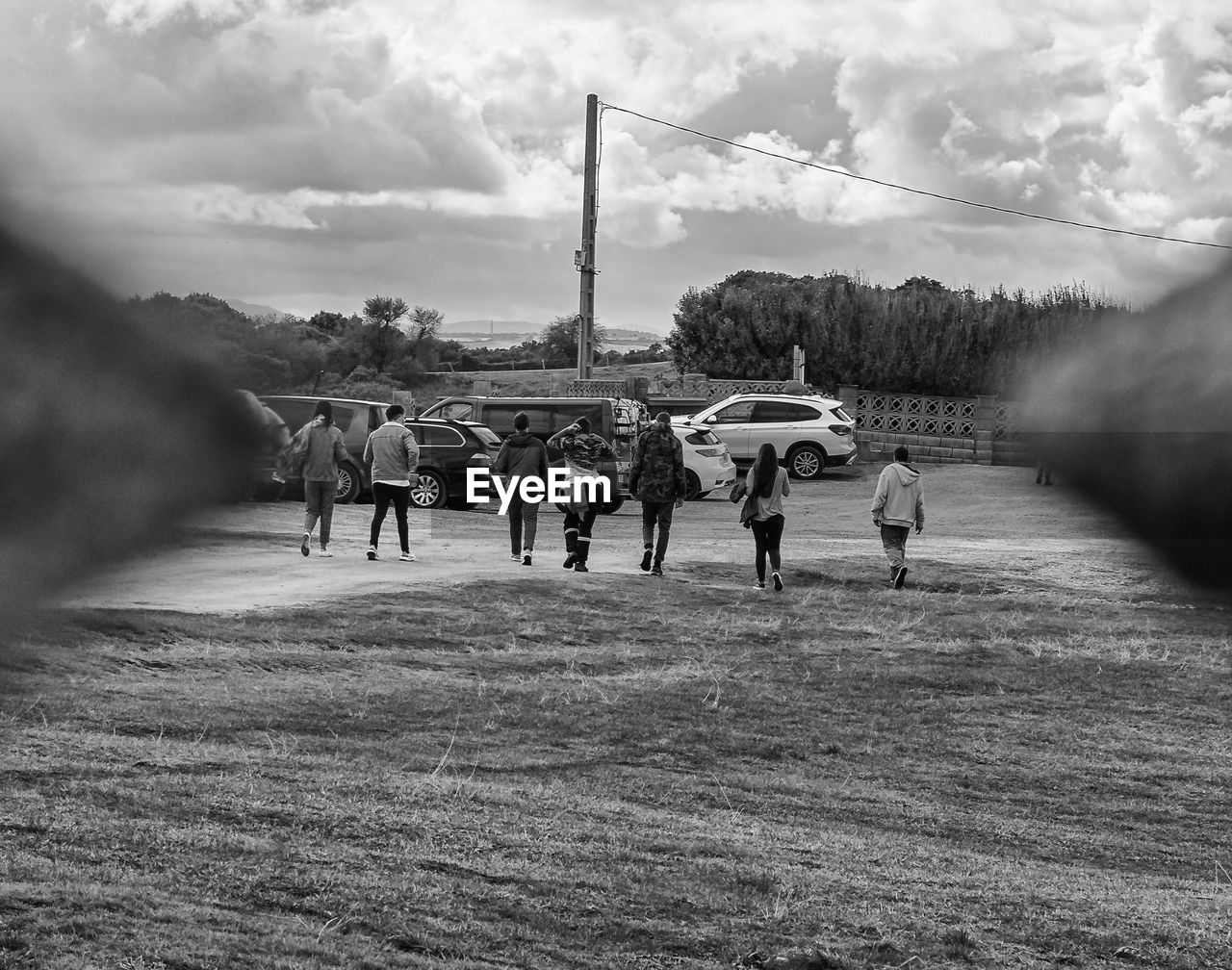 GROUP OF PEOPLE WALKING ON FIELD