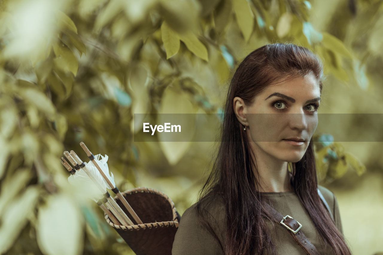 Portrait of beautiful archer while standing outdoors