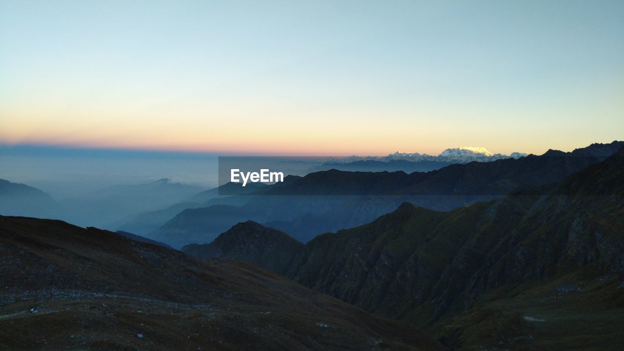 Scenic view of mountains against clear sky during sunset