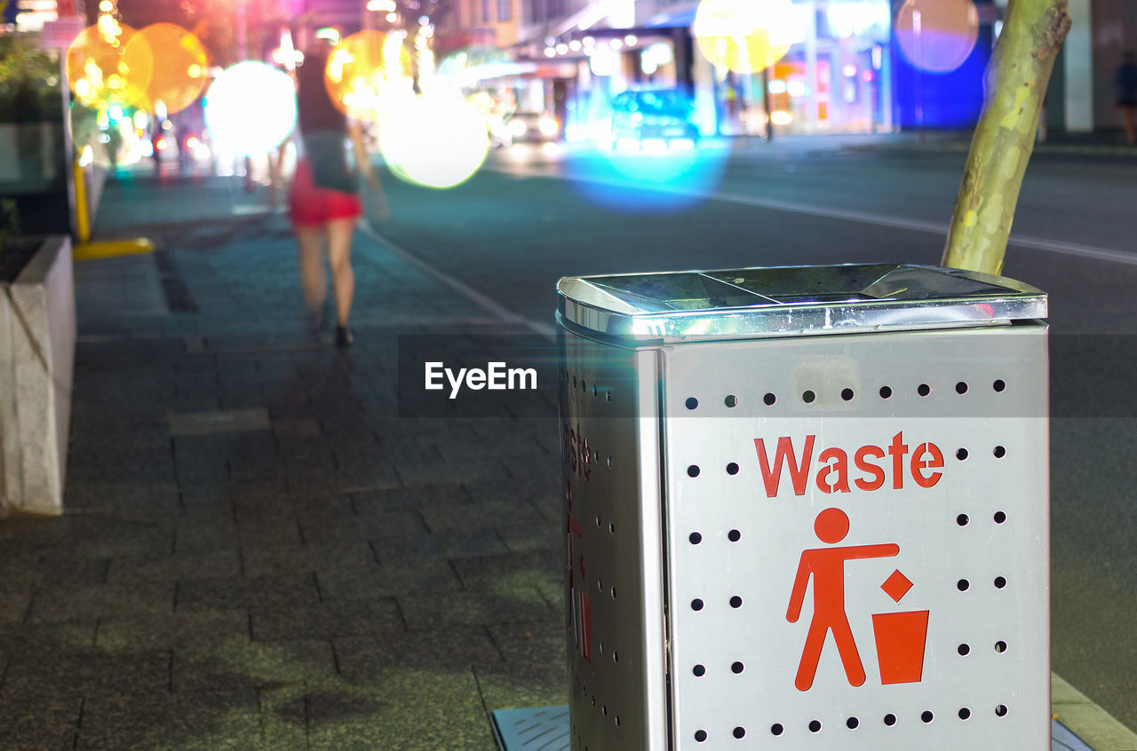 CLOSE-UP OF SIGN ON ILLUMINATED CITY