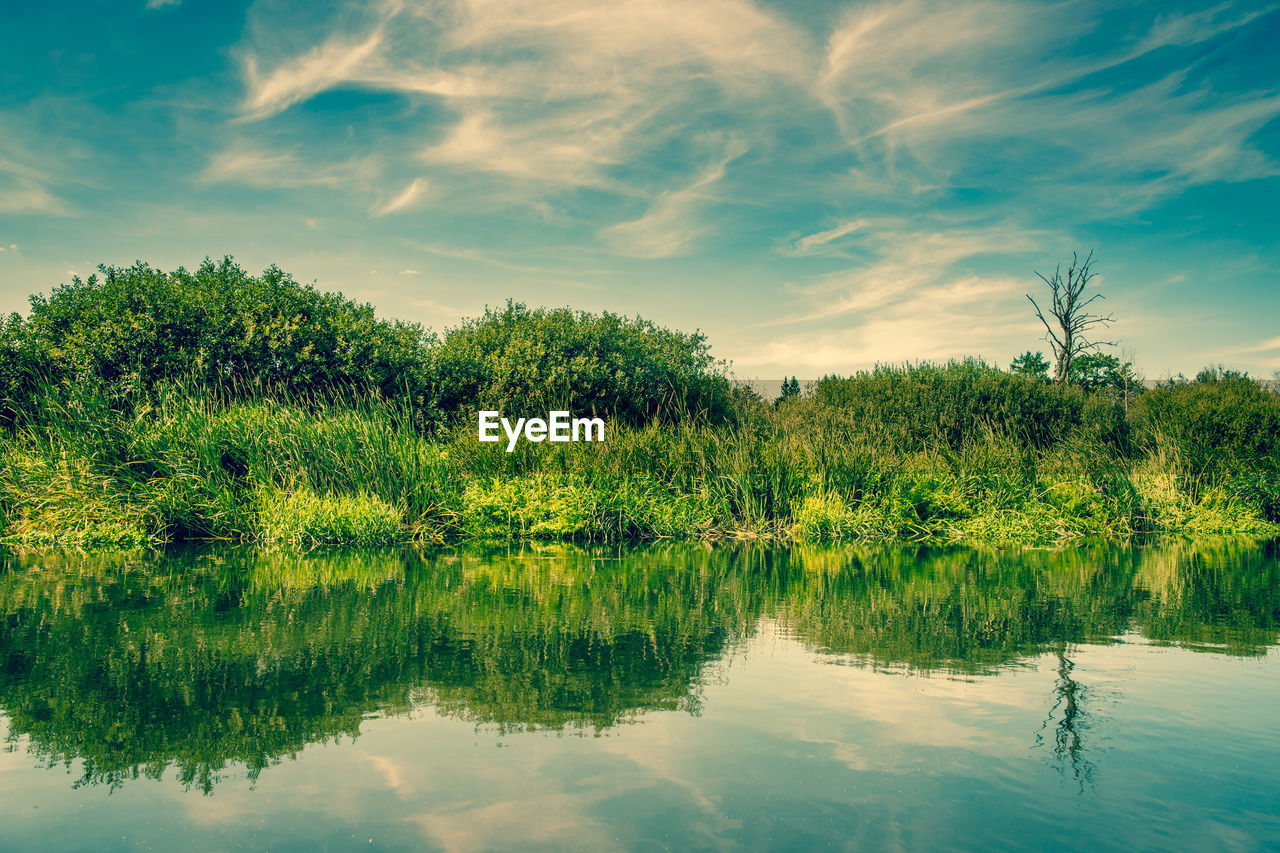 Scenic view of lake against cloudy sky