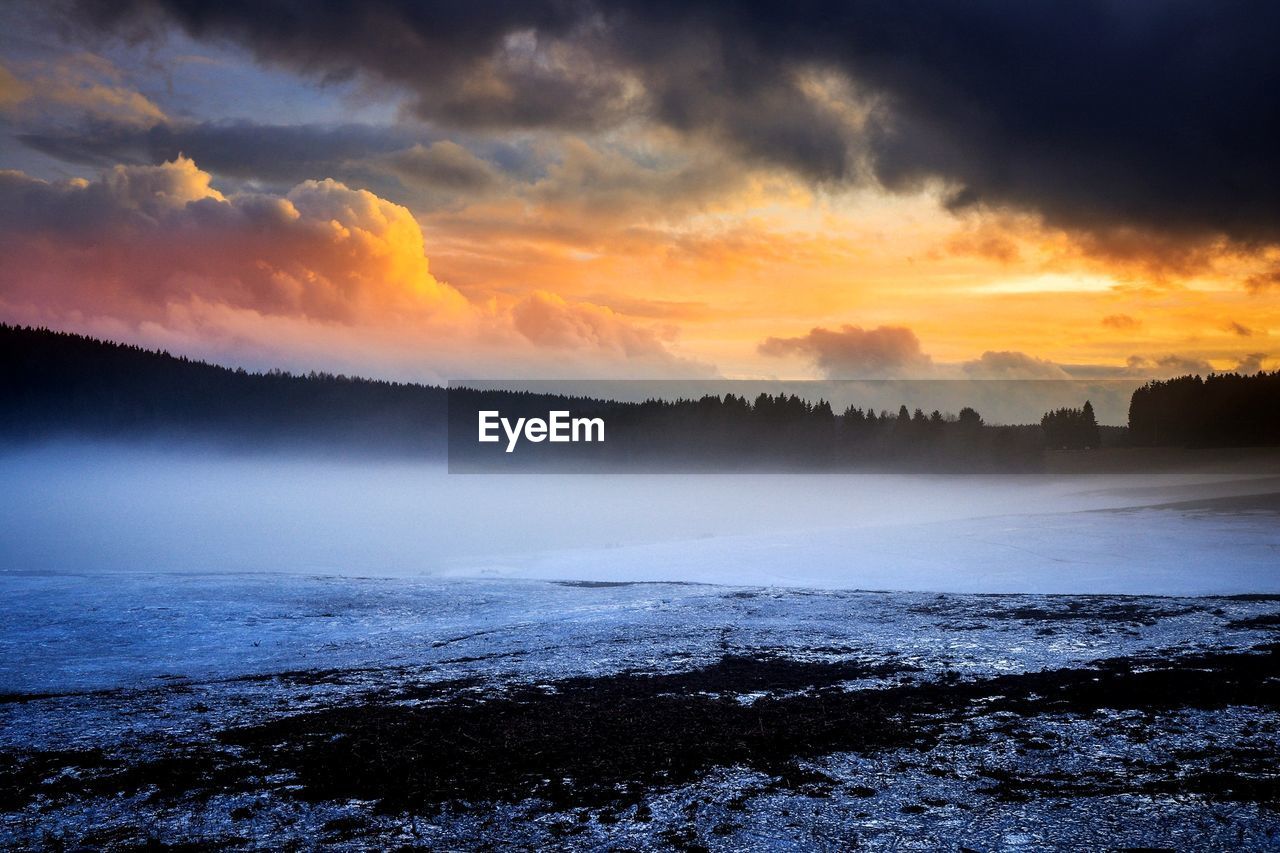 SCENIC VIEW OF SNOW COVERED LANDSCAPE AGAINST CLOUDY SKY