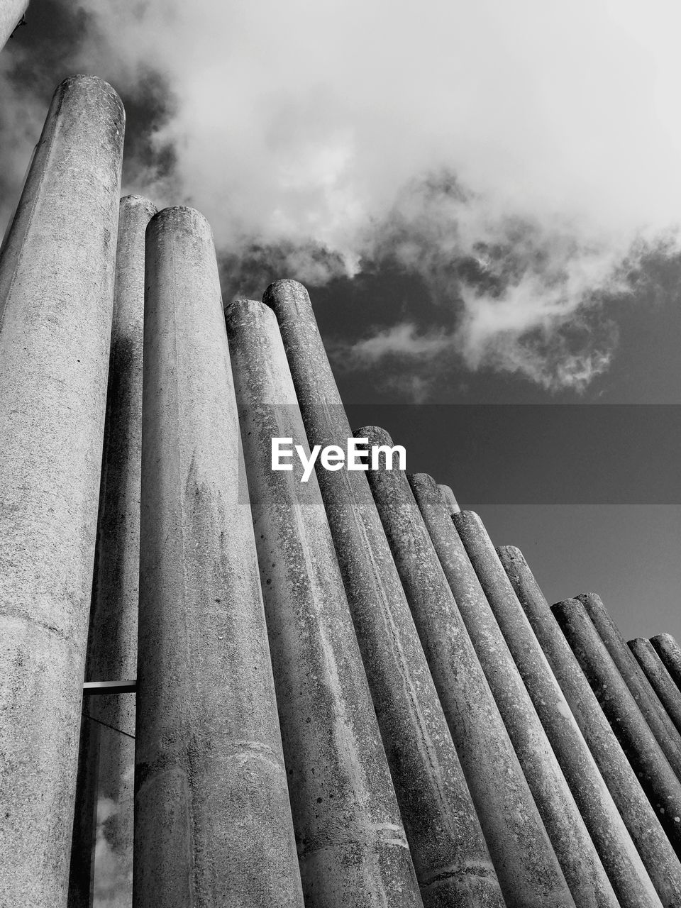 Low angle view of fence against cloudy sky