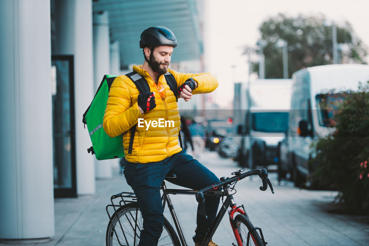 Smiling man sitting on bicycle on street