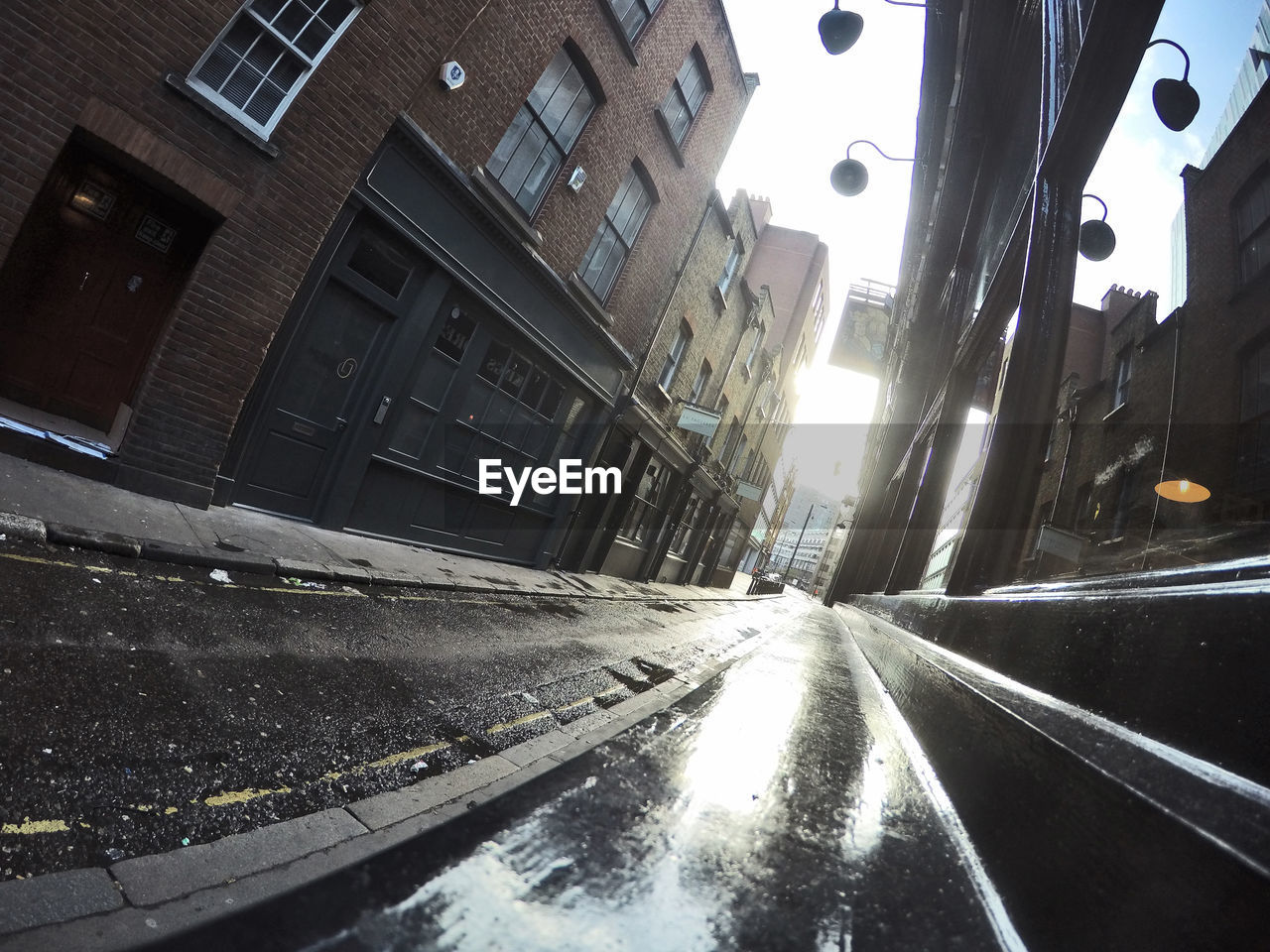 Tilt image of wet alley amidst buildings in town