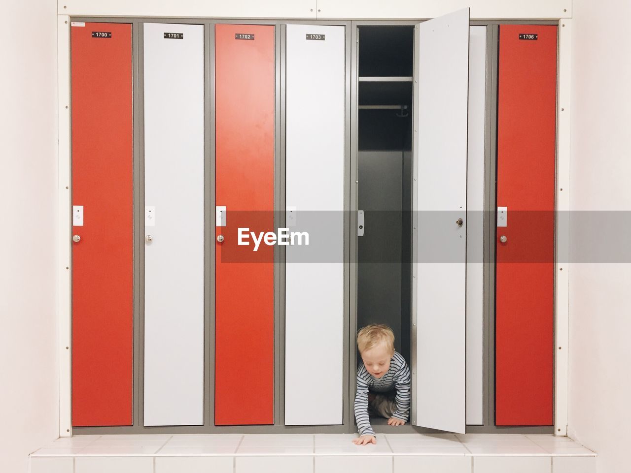 Playful boy hiding in locker
