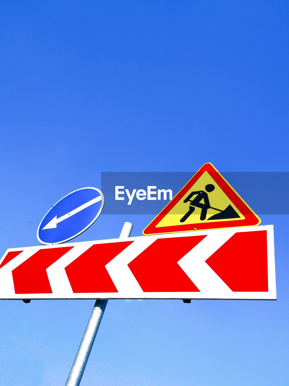 Low angle view of road sign against blue sky