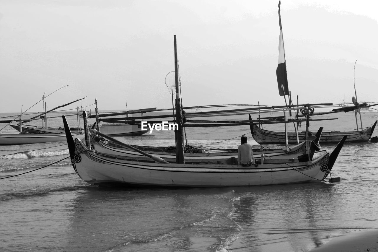 BOATS MOORED ON SEA AGAINST SKY