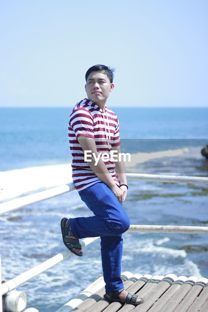 Full length of man standing in sea against sky