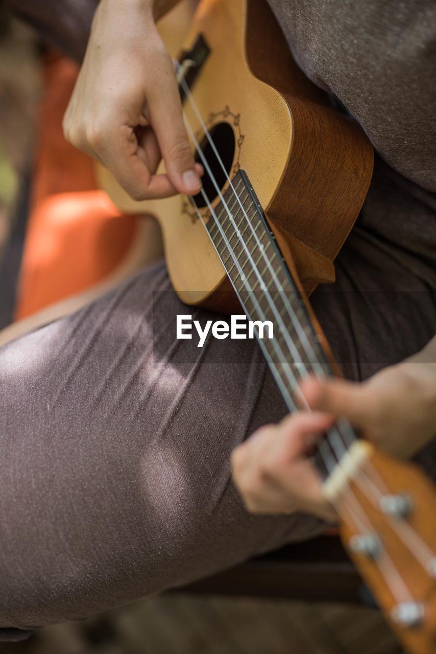 Cropped hands playing the ukulele