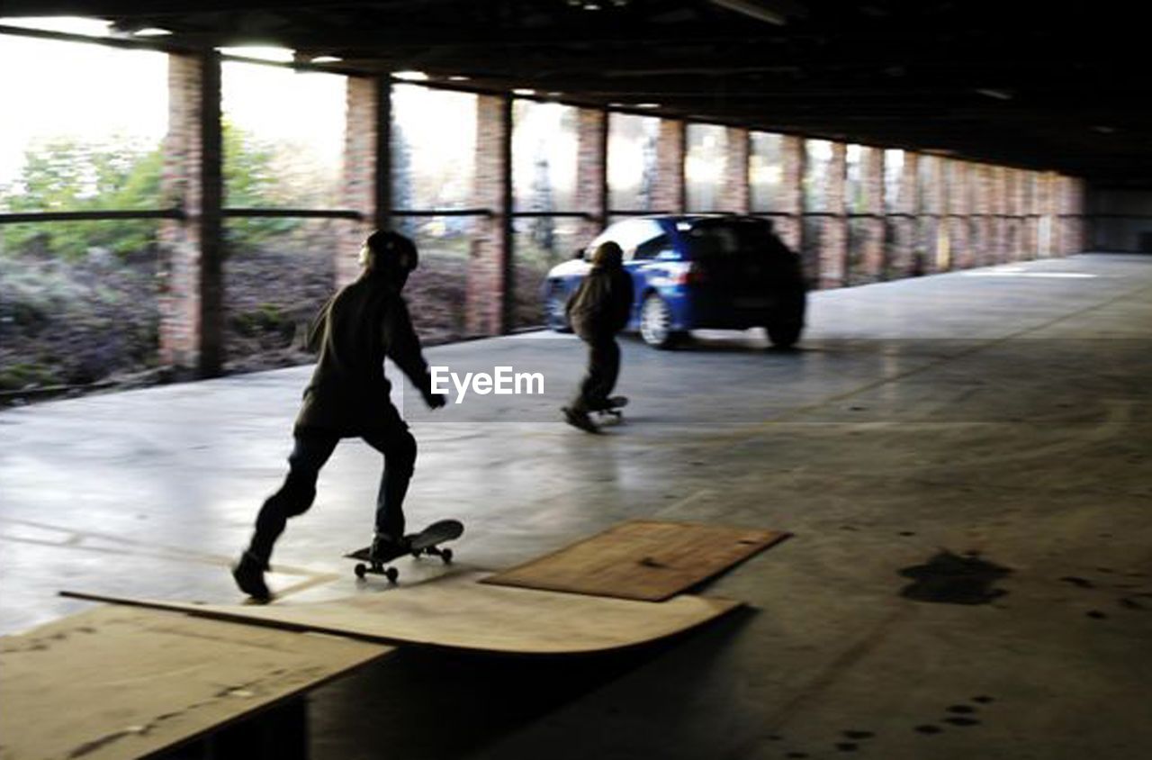 MEN WALKING IN CORRIDOR OF PEOPLE