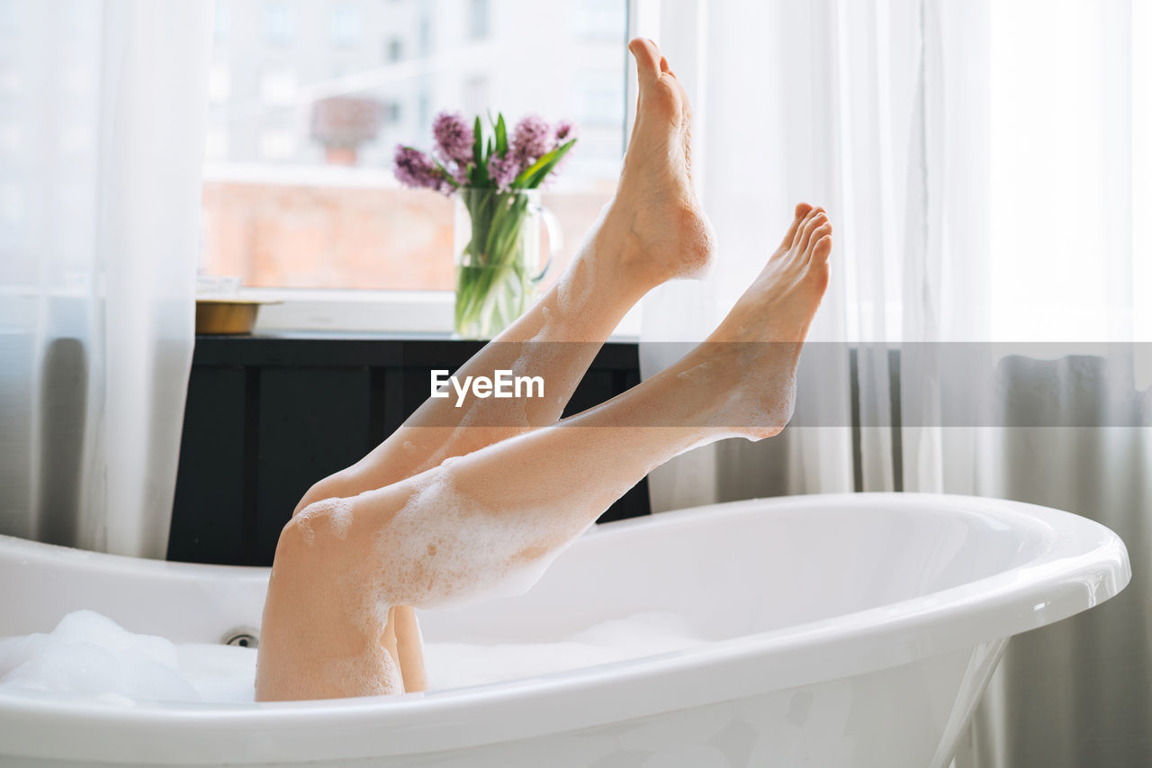 Young happy woman taking bath at home, treat yourself