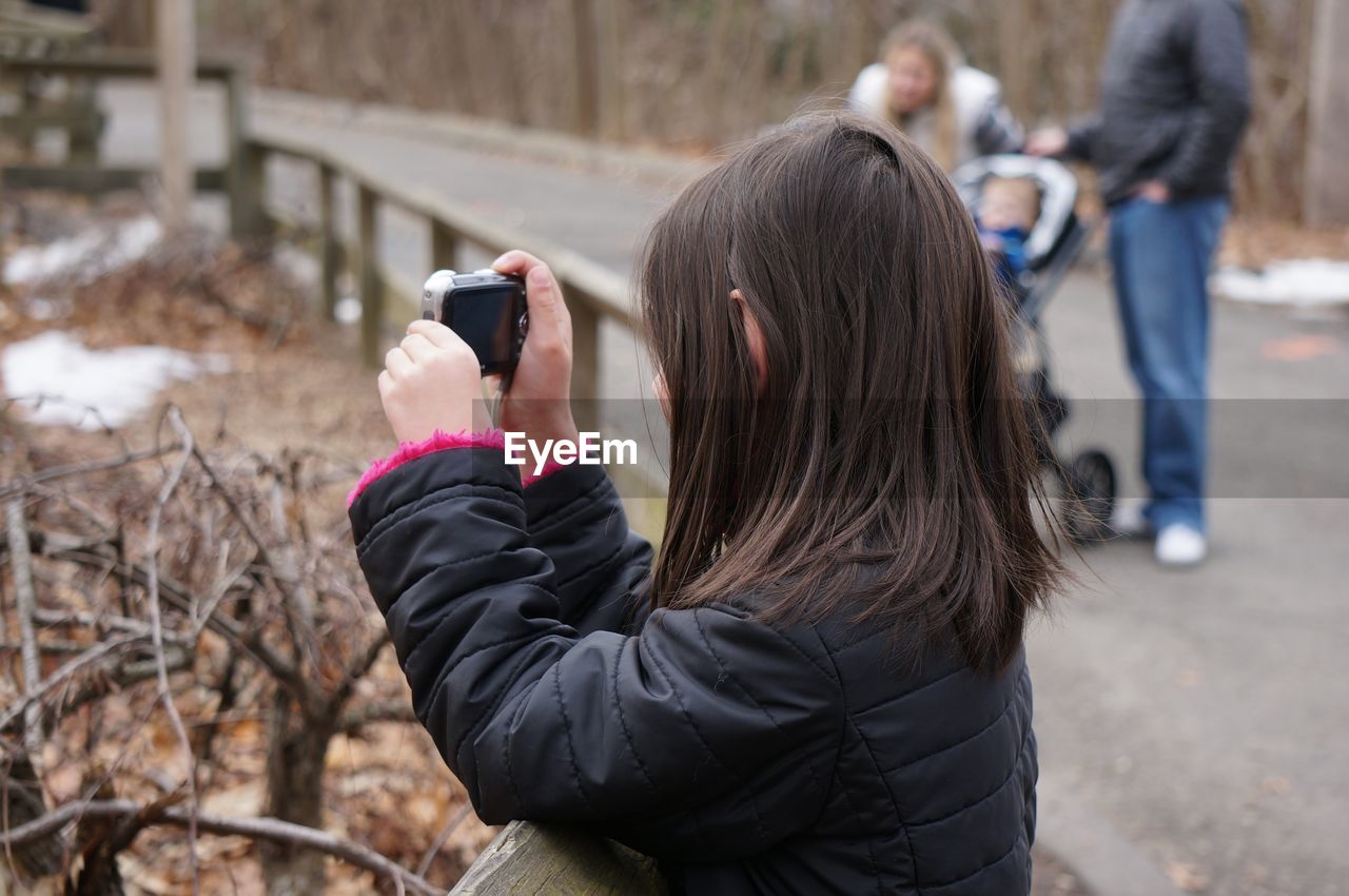 Side view of girl photographing