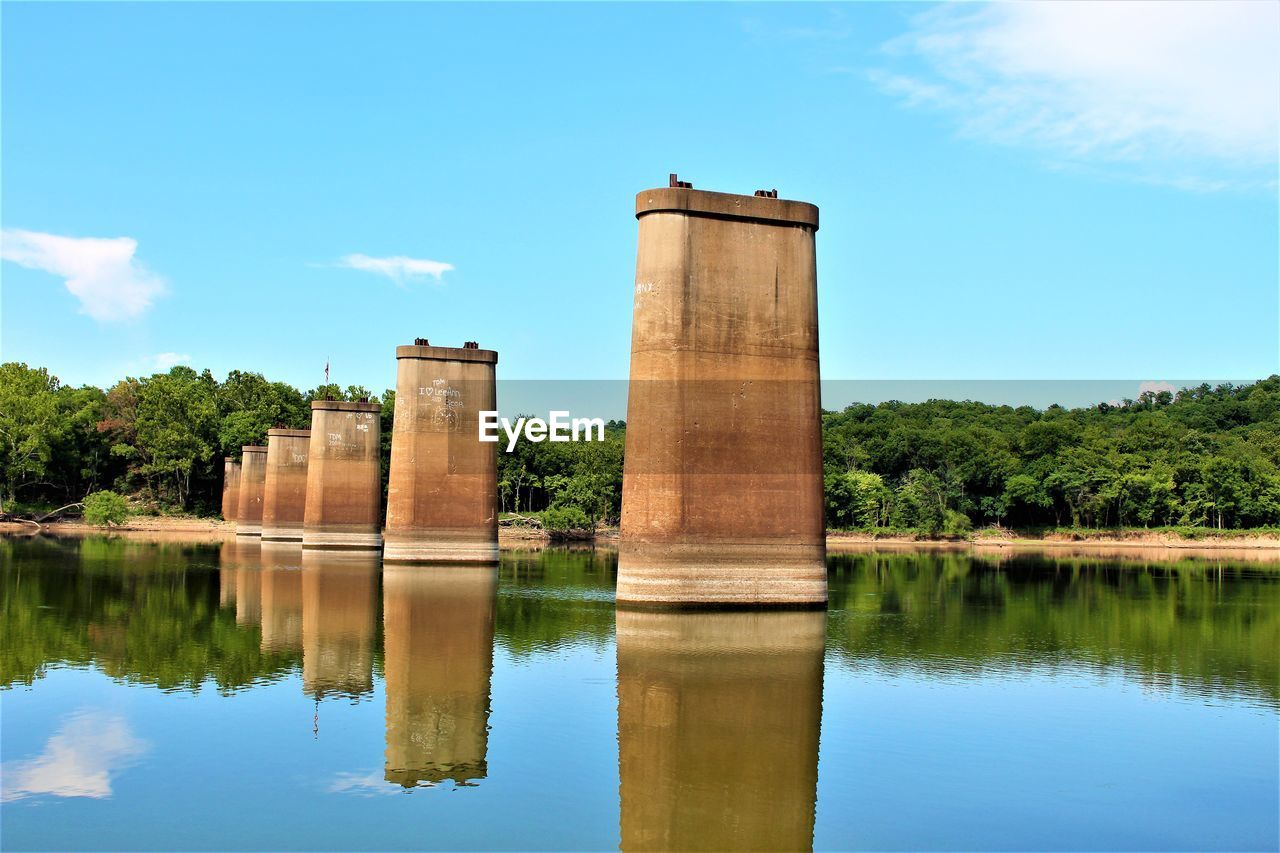 Built structure by lake against blue sky