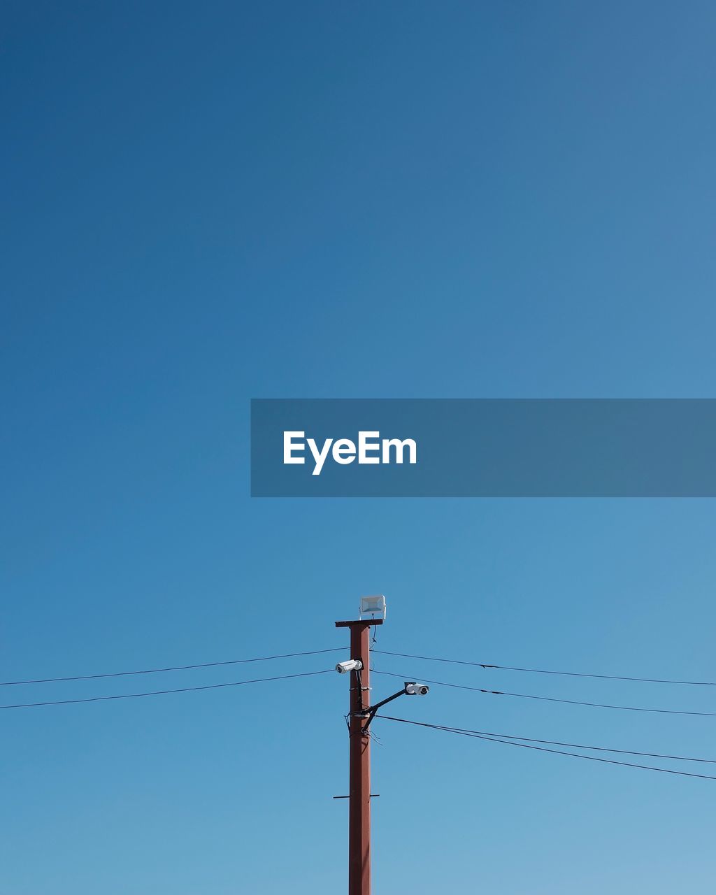 Low angle view of electricity pylon against blue sky