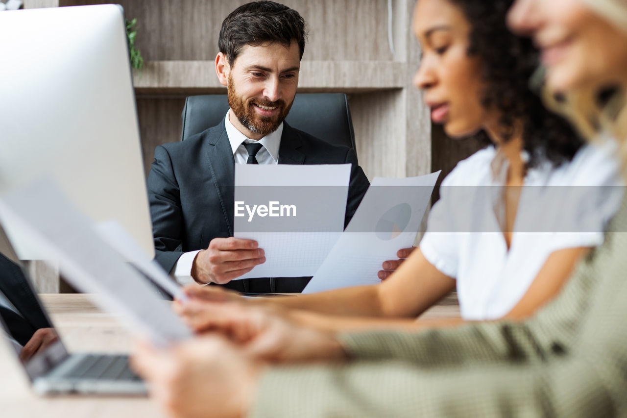 business colleagues using laptop at table