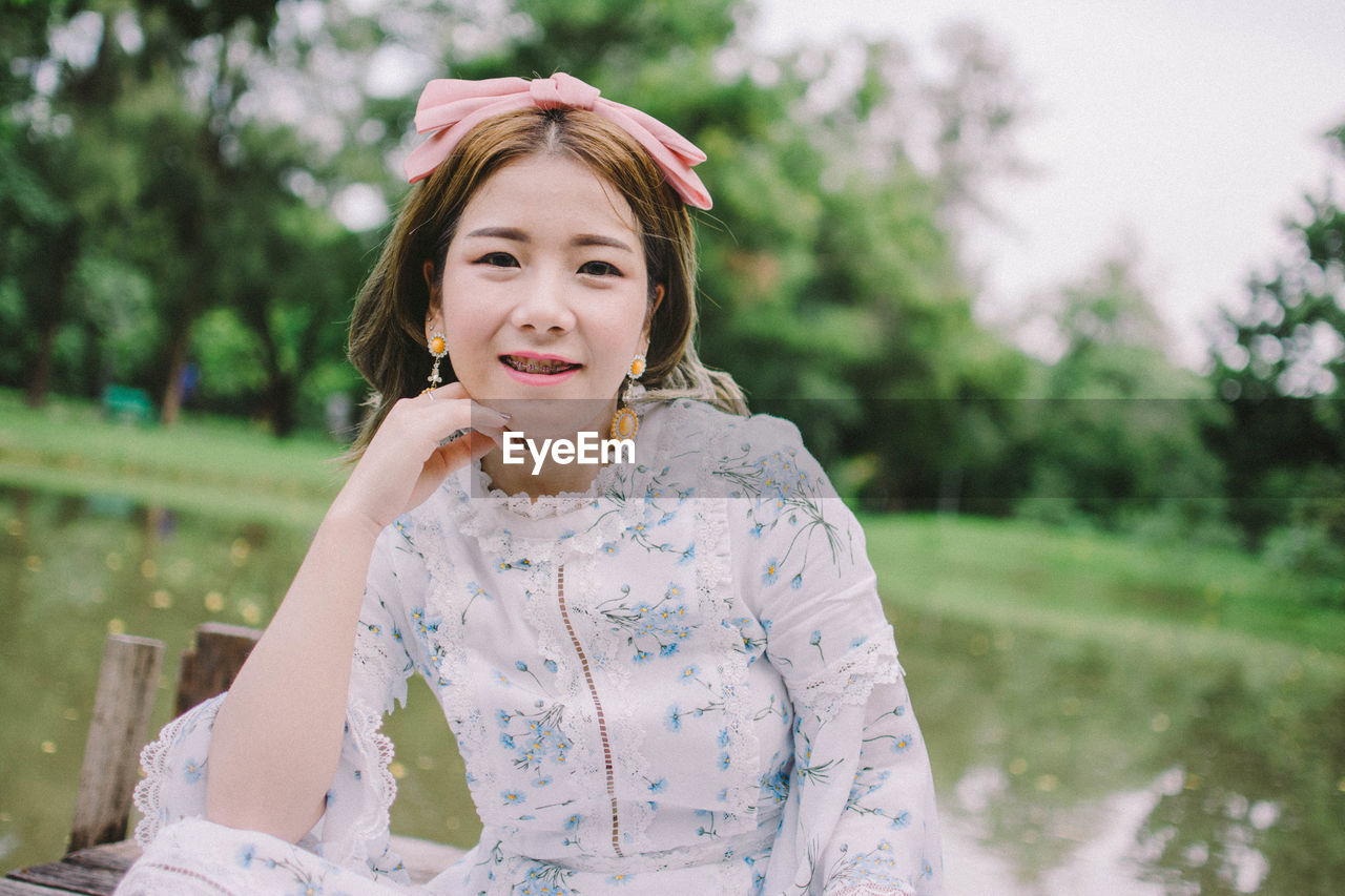 PORTRAIT OF YOUNG WOMAN SMILING OUTDOORS