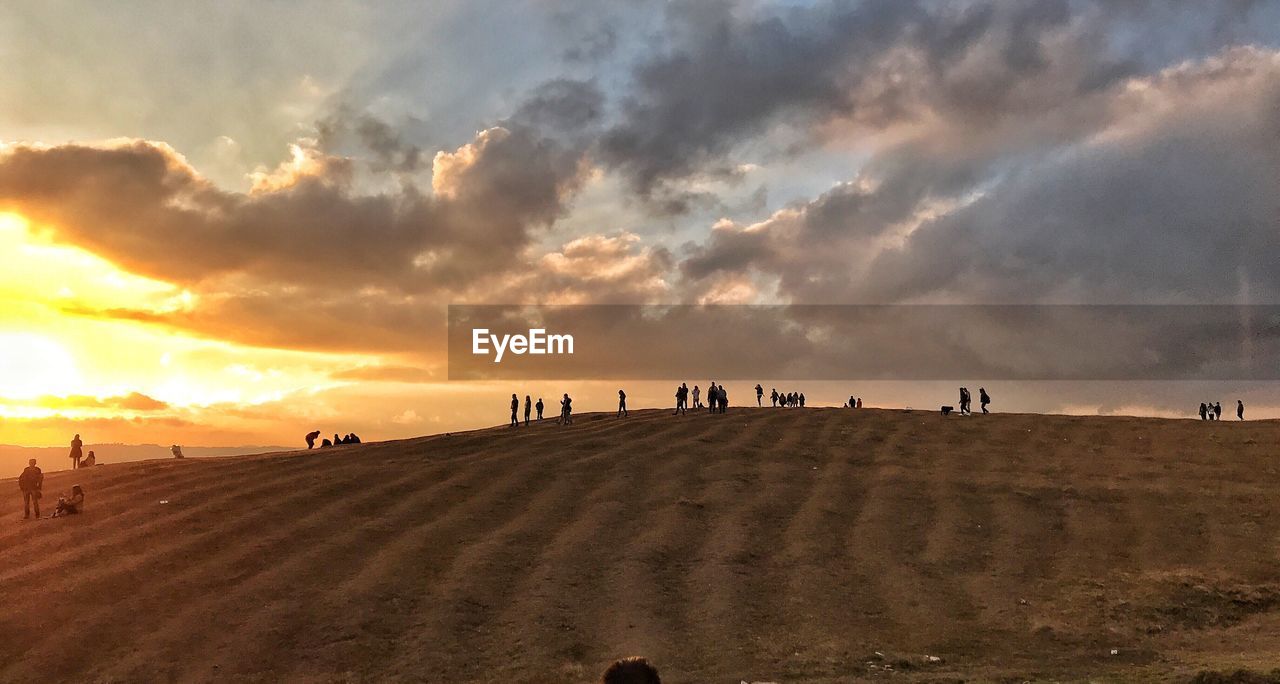 PANORAMIC VIEW OF PEOPLE ON BEACH AGAINST SKY