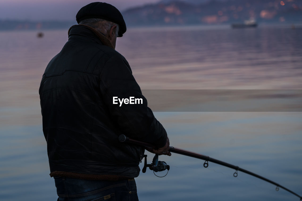 MAN FISHING AGAINST SEA