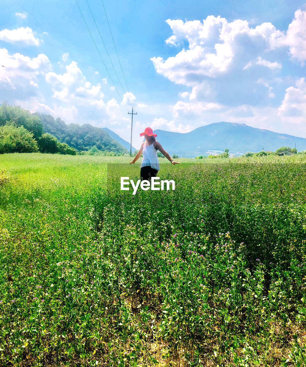 Woman standing by plants against sky