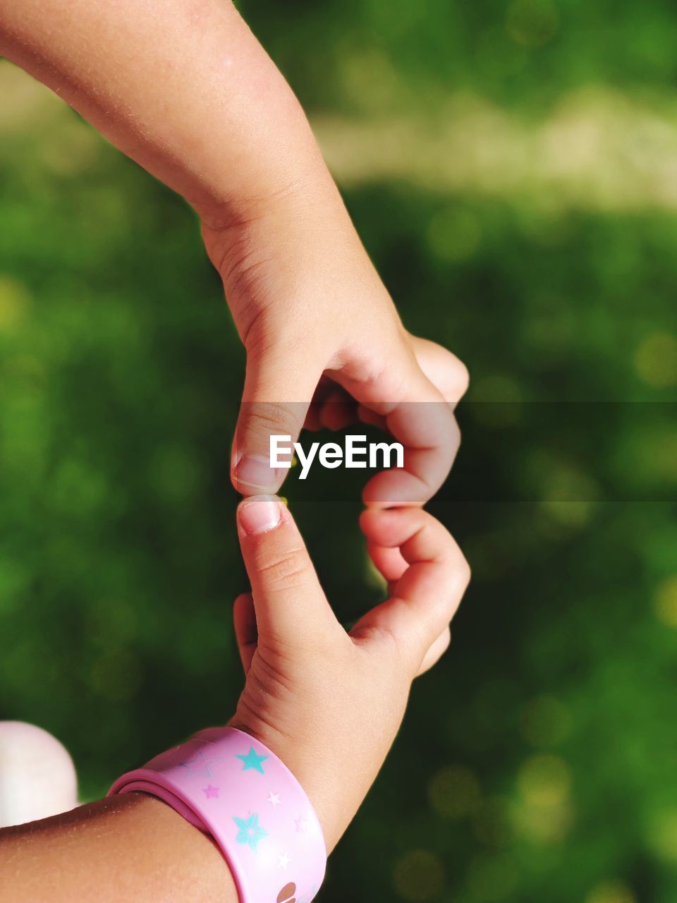 Cropped hands of child making heart shape