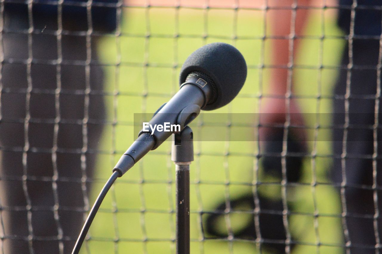 Close-up of microphone against fence