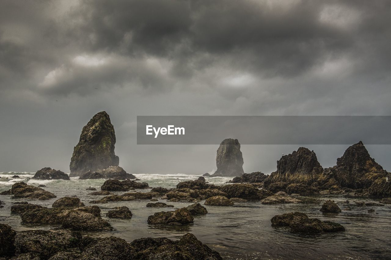 Rocks on sea shore against sky