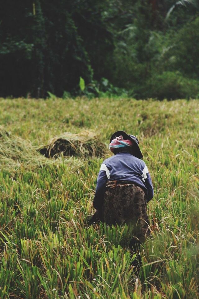 PERSON STANDING ON GRASSY FIELD