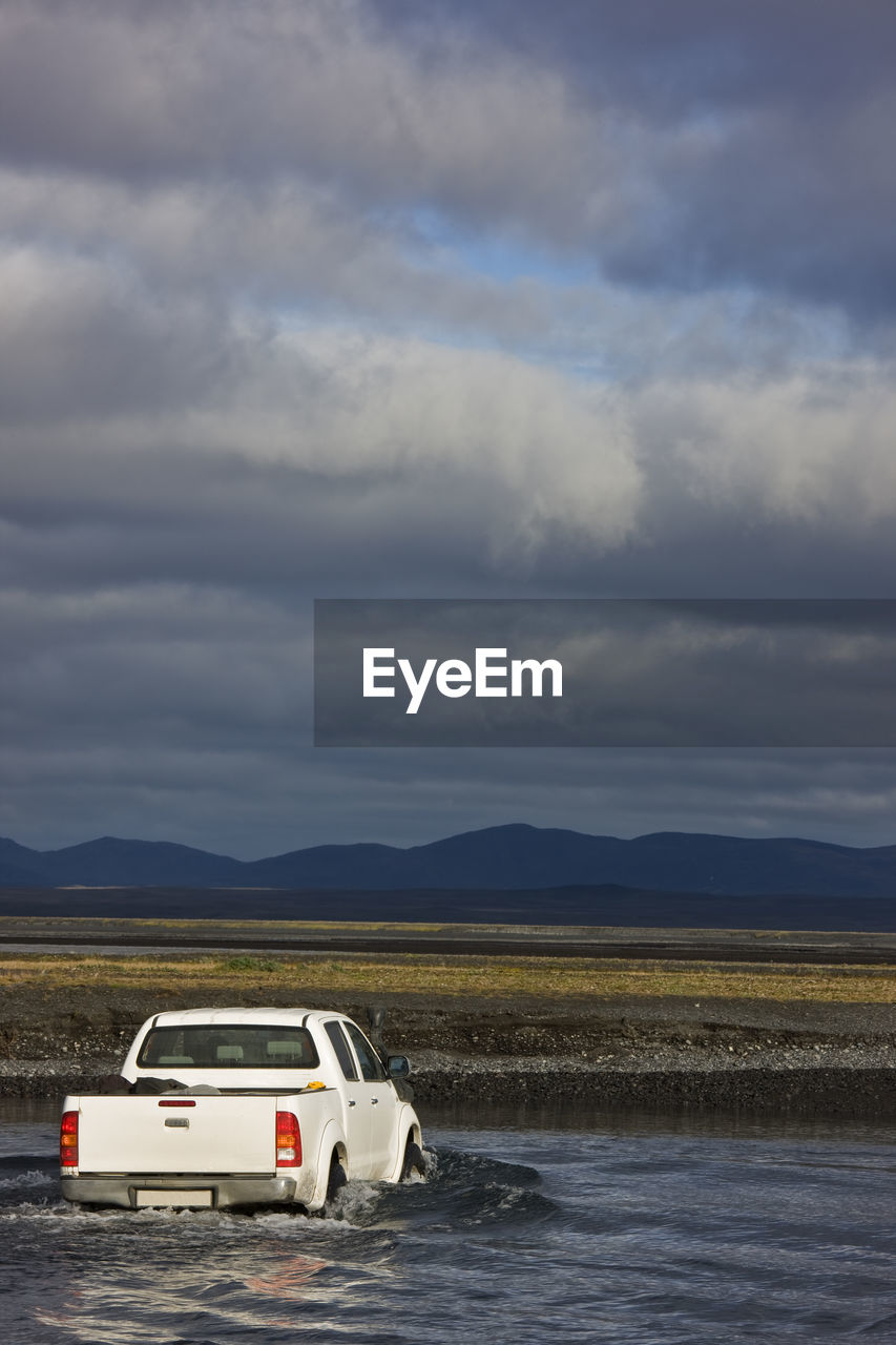 Pick up truck driving through stream on the icelandic highlands